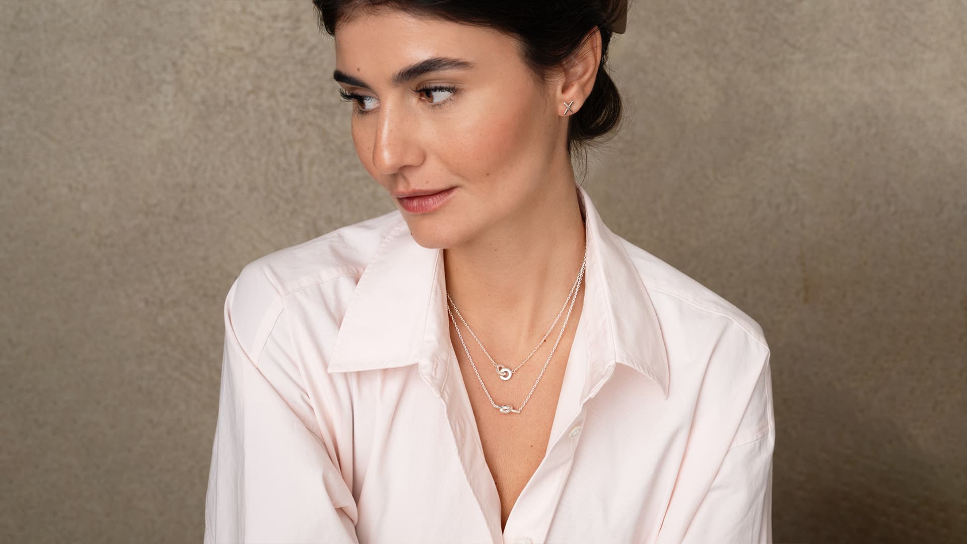 https://a.storyblok.com/f/329822/1920x1080/13f67f897b/16x9_stella_love-knot-necklace-you-me-necklace-kisses-for-ears.jpg